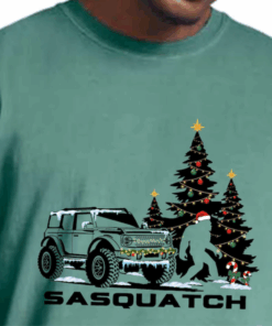 Ford Bronco Lover Christmas T-Shirt with Sasquatch Christmas Trees, Candy Cane Xmas Lights and Bronco Truck Printed on Shirt